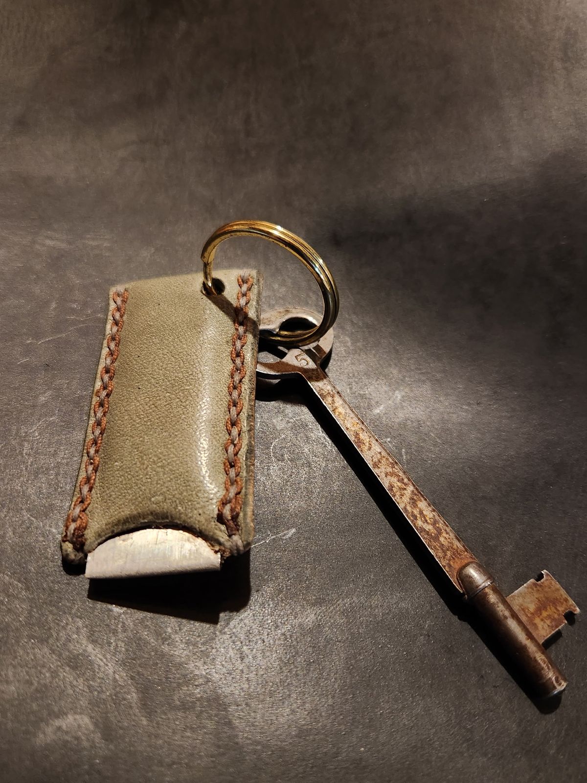 Photo by spyder550 on October 5, 2025 of the Self-Made Keychain/Bottle Opener in Wickett & Craig Grey Traditional Harness.