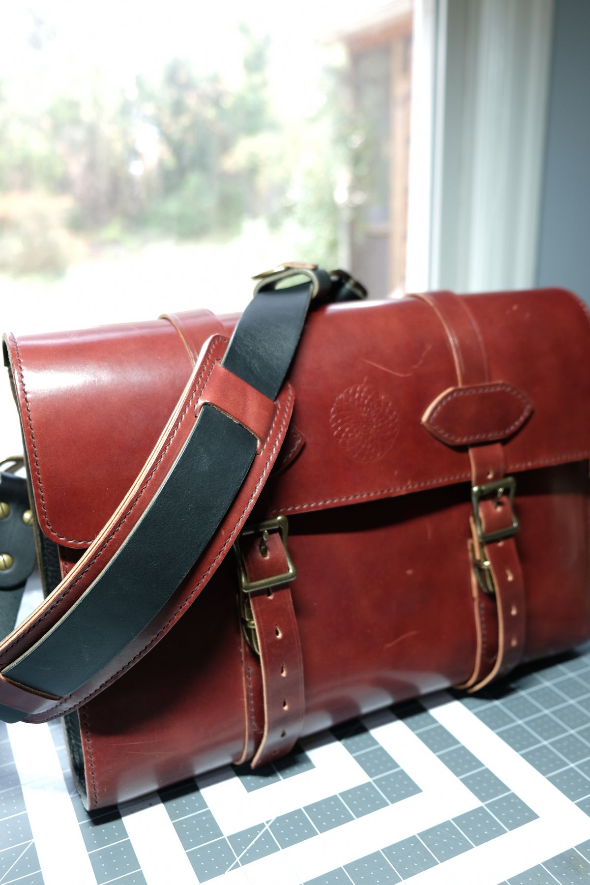 Photo by morosoleatherworks on December 5, 2025 of the Moroso Leatherworks Messenger Bag in Wickett & Craig Burgundy Burnt Harness & Wickett & Craig Black Milled Traditional Harness.
