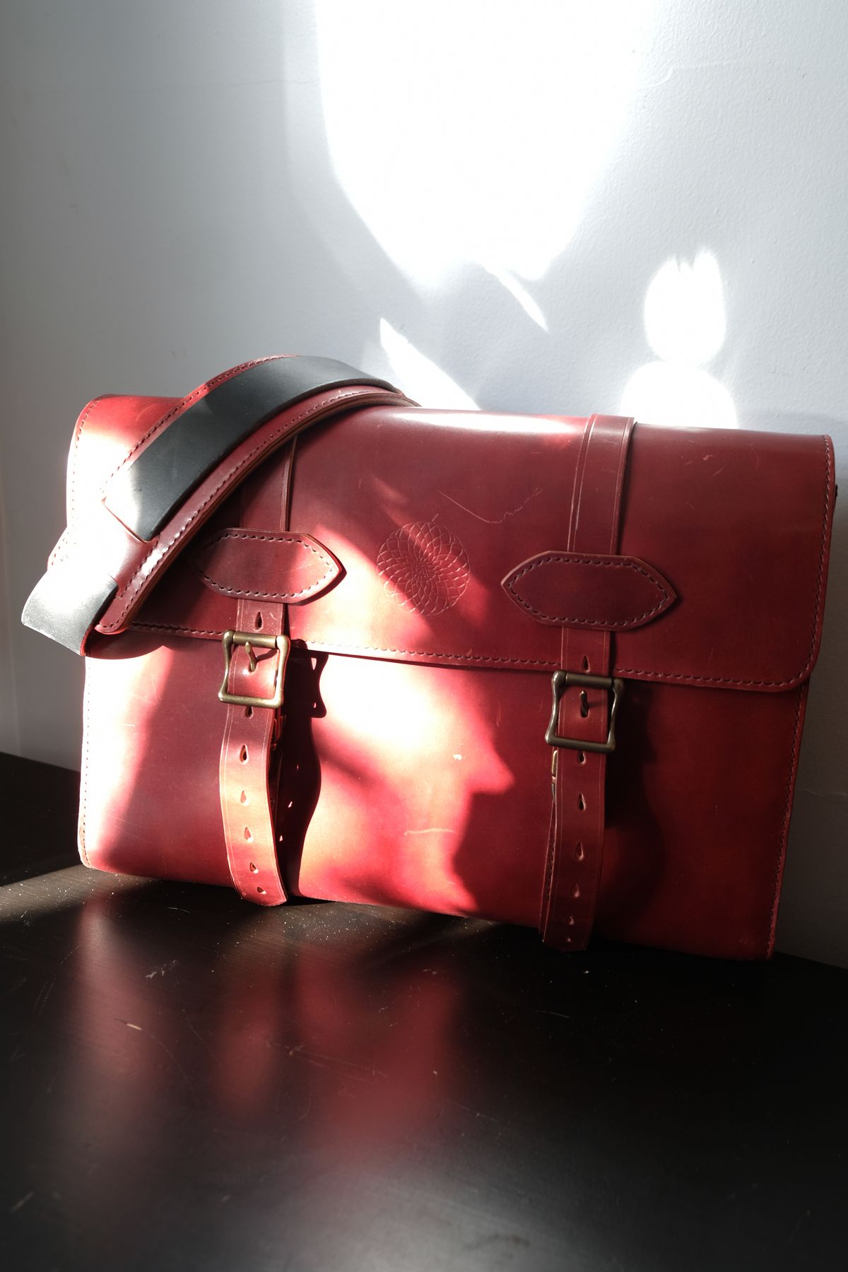 Photo by morosoleatherworks on December 31, 2025 of the Moroso Leatherworks Messenger Bag in Wickett & Craig Burgundy Burnt Harness & Wickett & Craig Black Milled Traditional Harness.